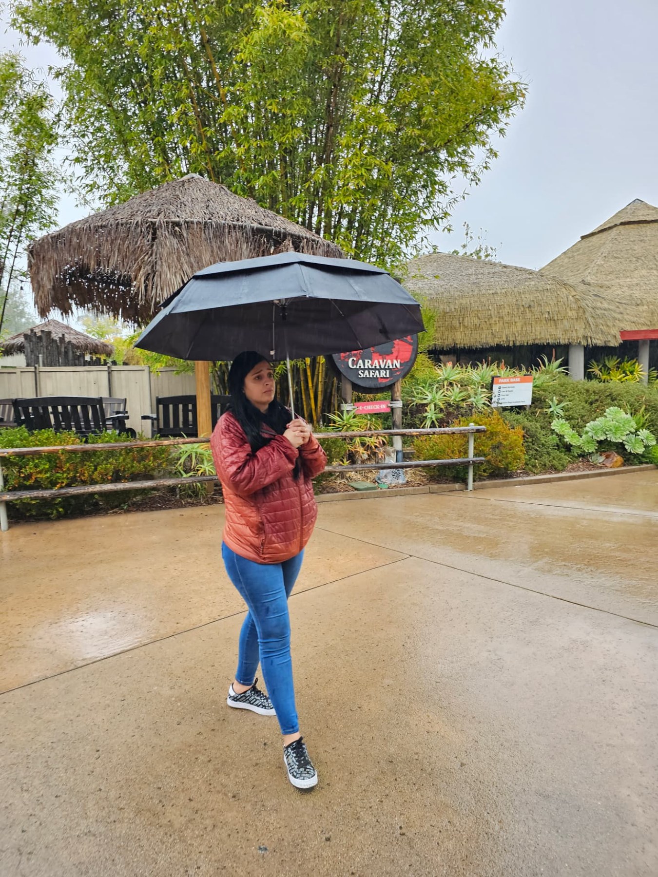 Expressive Margarita under her umbrella at the zoo after four hours in the rain — ready to BOUNCE