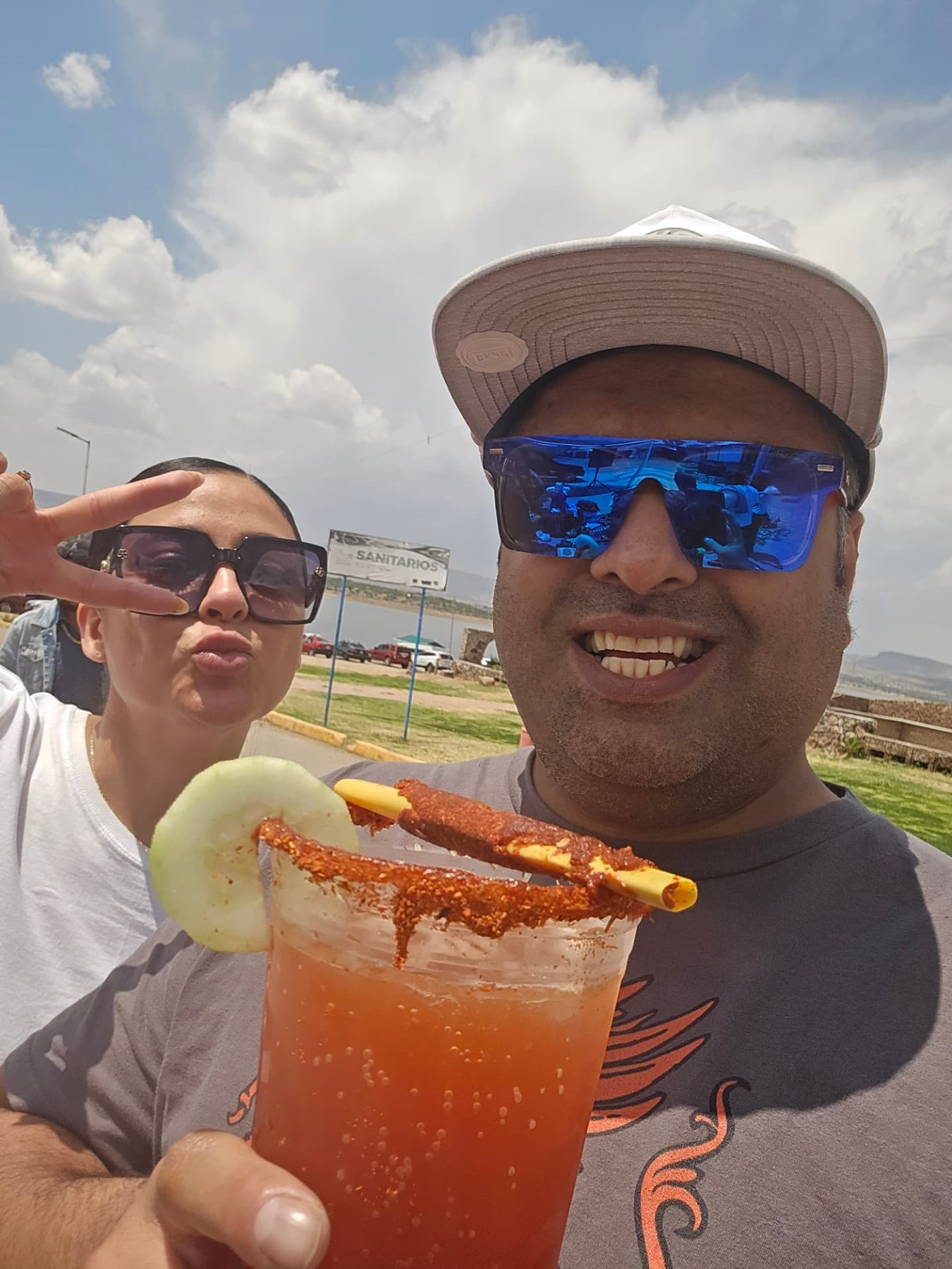 Margarita and Samir with a colorful drink on their travels
