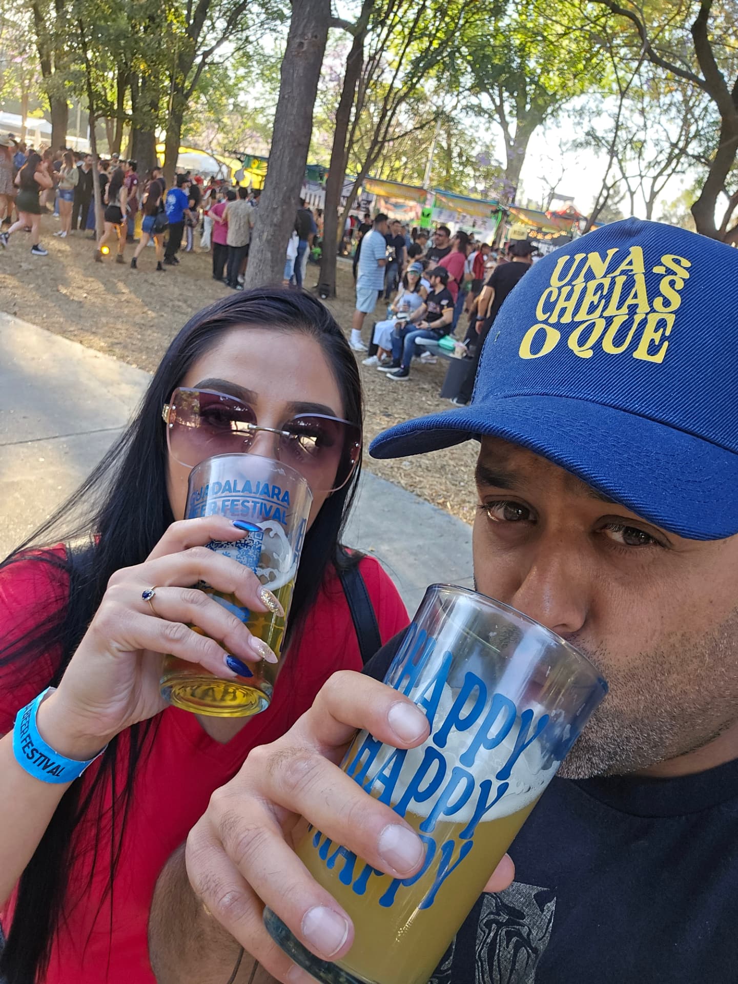 Margarita and Samir clinking festival glasses at the Guadalajara Beer Festival