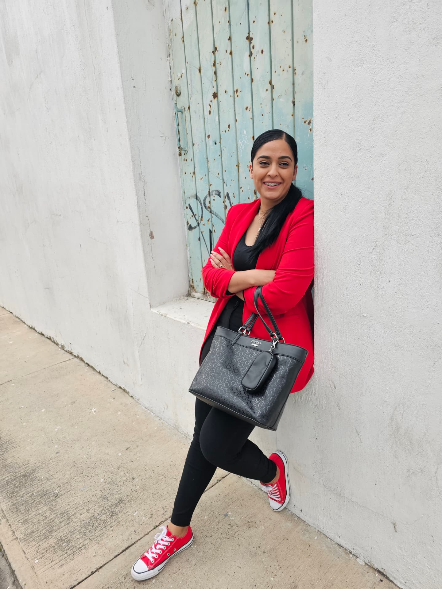 Margarita in her red jacket beside a pale blue door