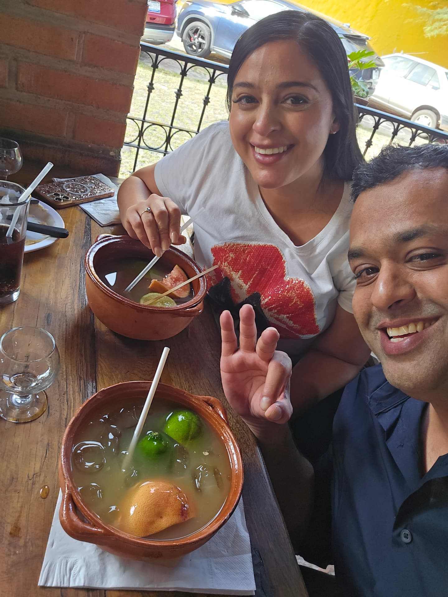 Margarita and Samir smiling over cantaritos at a restaurant table