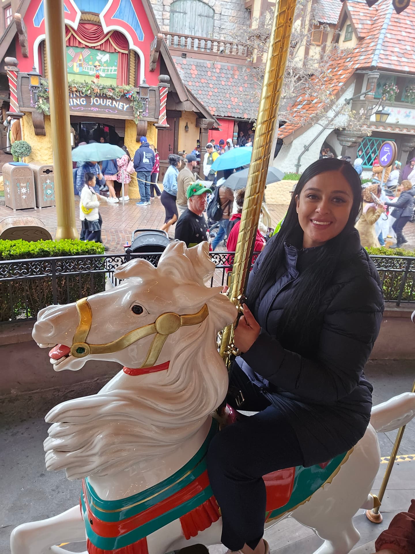 Margarita riding a white carousel horse at Disneyland
